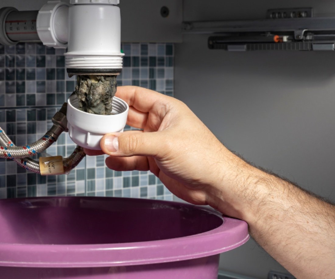 Siphon bouché démonté sous un évier